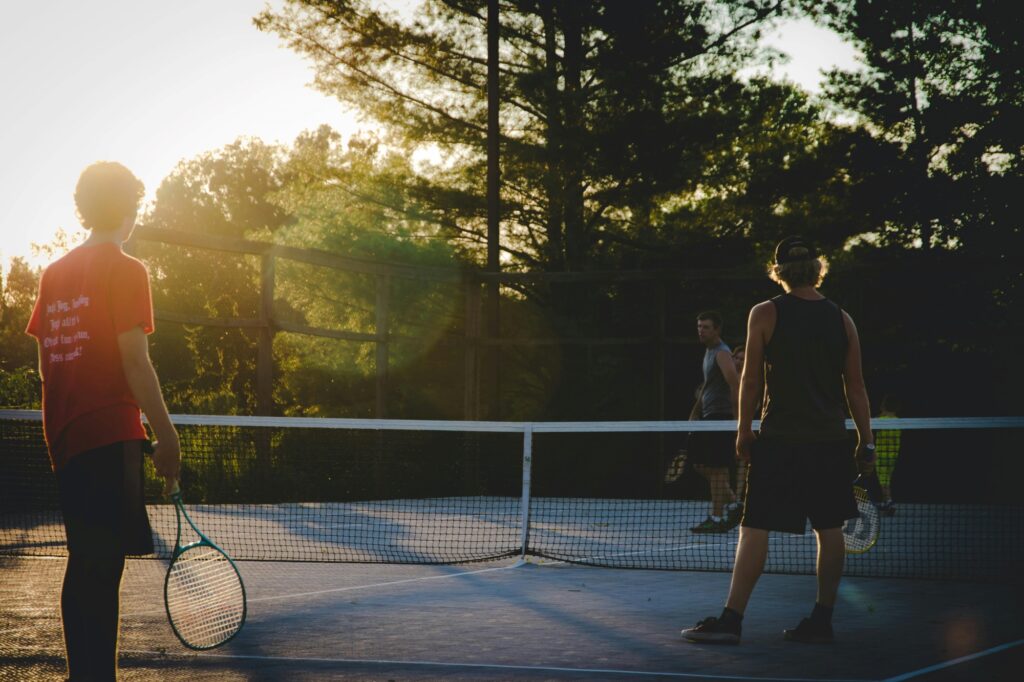 A tennis court with young men playing