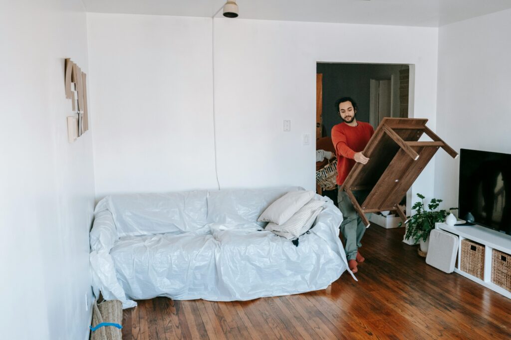 A couple is carrying household items into their new house in the concept of affordable housing in Weymouth.