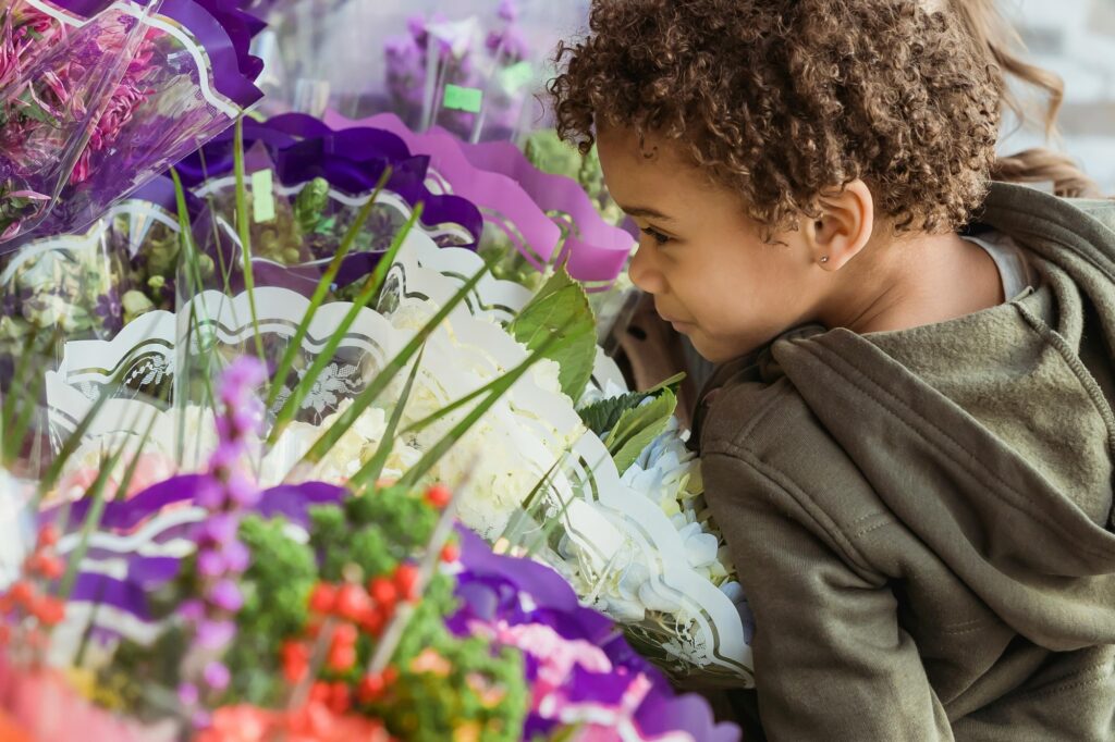 Cropped image of a child smelling flowers in the flower market