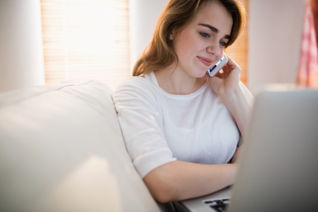 A woman speaking with a man and van on the phone to get a quote