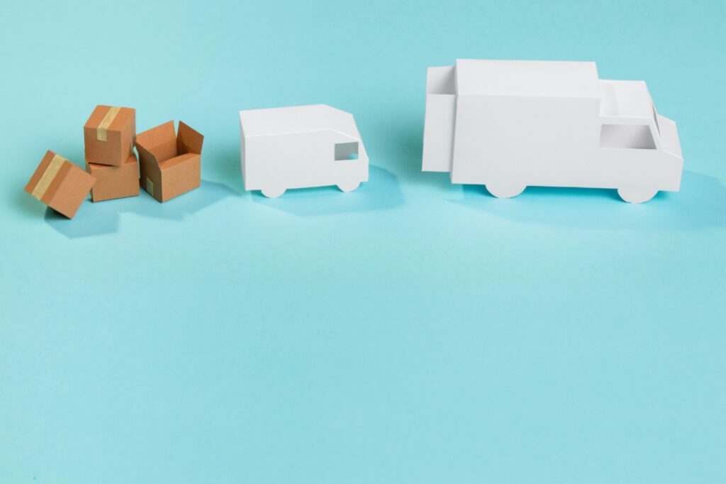Small van, moving truck, and boxes made in paper in the concept of 'Differences Between Man and Van Services and Traditional Removals'.
