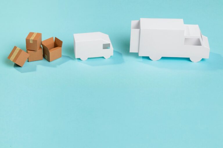 Small van, moving truck, and boxes made in paper in the concept of 'Differences Between Man and Van Services and Traditional Removals'.